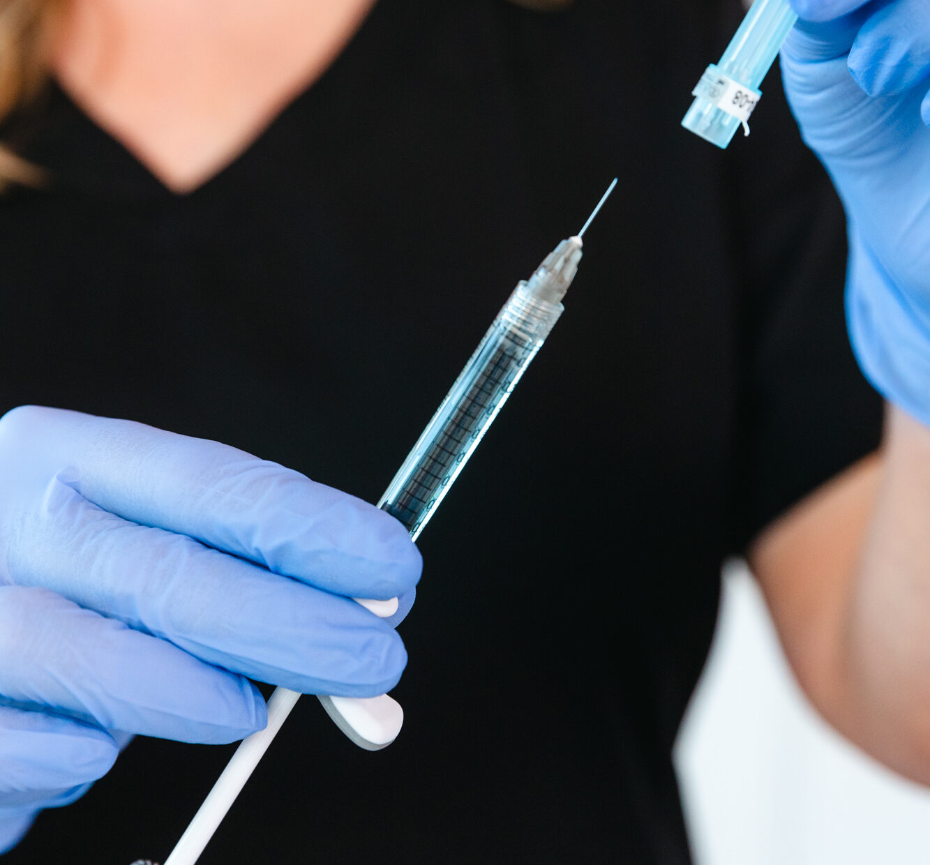 A provider wearing gloves holds a syringe and prepares an injection of lip filler in Brentwood, TN